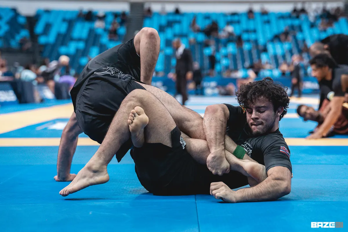 Bernardo Mastrangelo disputando a guarda em competição, controlando a perna do adversário