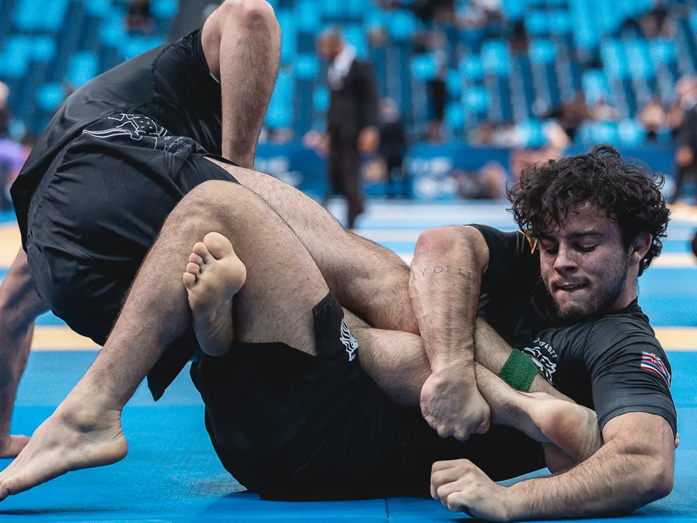 Bernardo Mastrangelo em cross ashi durante competição, controlando a perna do adversário